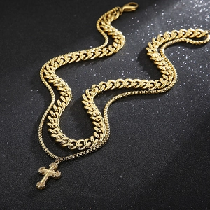 Detail of double-layer gold stainless steel necklace with cross pendant and Cuban chain