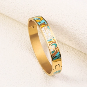 Detail of 18K gold plated bangle featuring colorful enamel patterns and hinged clasp