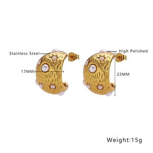 Detail of 18k gold plated stainless steel C-shaped earrings with hammered texture and pearls