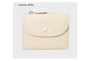 Detalle de una cartera sobre blanco crema con textura de cuero y botón de presión