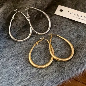 Minimalist oval horseshoe hoop earrings in polished gold and silver finishes