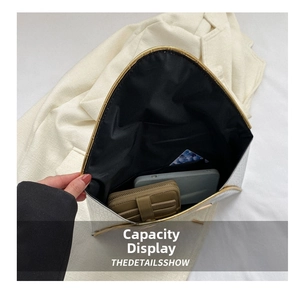 Internal view of a white envelope clutch bag showing storage for phone and wallet
