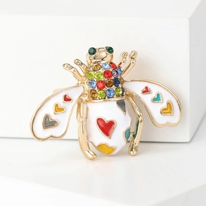 Golden enamel honey bee brooch with colorful crystals and heart patterns on white background