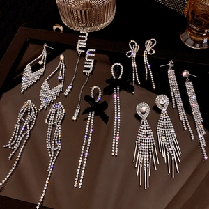 Close-up of elegant silver earrings with sparkling rhinestones and black satin bows