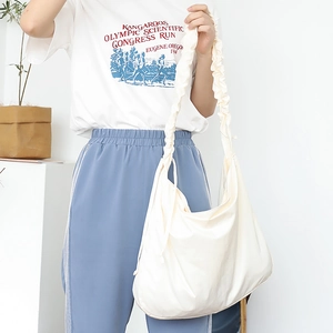 Minimalist off-white canvas shoulder bag with a unique ruched strap design for women