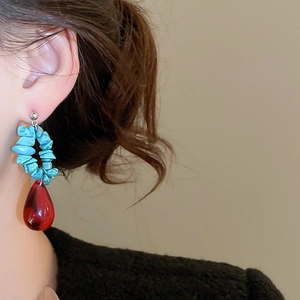Ethnic style earring detail with sky blue stone beads and red water drop pendant
