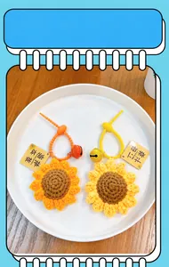Detailed view of two crochet sunflower keychains with First Prize lucky tags