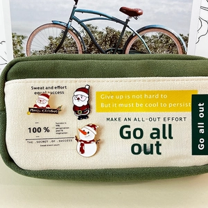 Detail of Christmas brooches and Santa badges on a green canvas pencil case