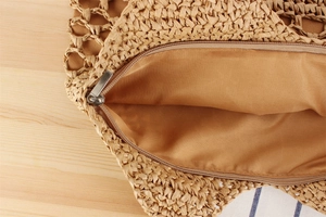 Detail shot of the secure zipper closure and durable lining on a woven paper rope bag