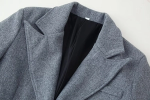 Close-up of the notch lapel and grey wool blend texture on this long fashion coat