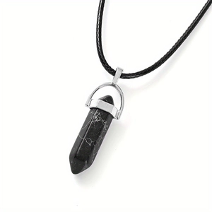 Détail macro du pendentif hexagonal en pierre noire avec fermoir argenté et cordon noir