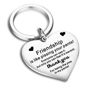 Close-up of heart-shaped stainless steel keychain with funny friendship engraving