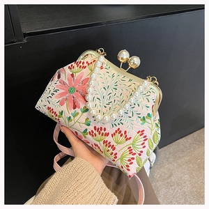 Detailansicht der Blumenstickerei auf rosa Tasche mit Perlengriff und Metallverschluss