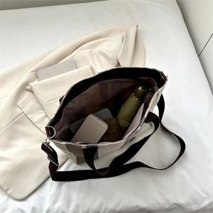 Large striped canvas tote bag with inner storage for daily items on minimalist bedding