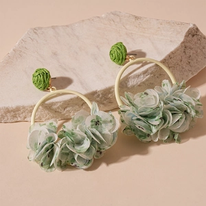 Detail view of floral fabric earrings with green woven stud on a natural stone base