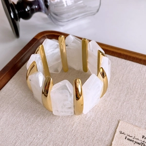 Detail of marble resin blocks and gold metallic bars on an elegant elastic bracelet