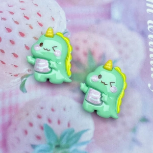 Close-up of cute green resin dinosaur charms for DIY hairpins and craft decorations