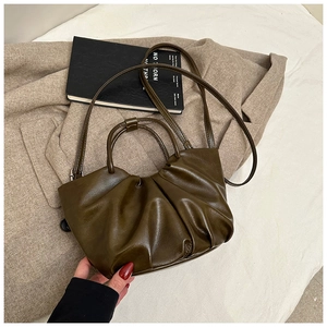 Detail of dark olive green pleated dumpling bag with soft leather texture and strap