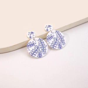 Detail view of round blue and white porcelain pattern earrings with leaf vein texture