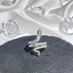 Macro shot of silver snake ring with scale texture on dark stone with ice accents
