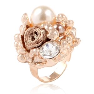 Détail d'une bague avec rose, perles et anneau doré à texture vintage réglable