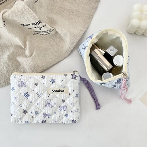 Quilted floral cosmetic bag with bear print showing interior storage for makeup