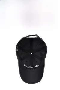 Detail of the inner sweatband, reinforced lining, and metal buckle of the black cotton cap