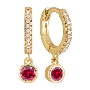 Detail of gold hoops with pavé white zircons and a round red gemstone pendant charm