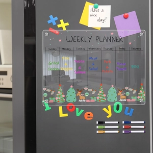 Magnetic acrylic weekly planner on fridge with colored markers and festive decorations