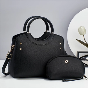 Detail of black lychee grain leather tote bag set with gold studs and tulip decoration
