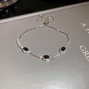 Adjustable silver bracelet featuring three oval black gemstones with bolo clasp detail