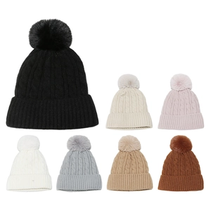 Détails de sept bonnets d'hiver en maille torsadée avec de grands pompons en fausse fourrure