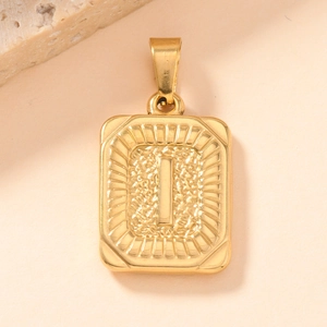 Macro shot of gold-plated rectangle pendant with embossed letter I and textured finish