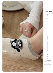 Close-up of knit penguin pattern low-cut socks with warm downy lining on wooden floor