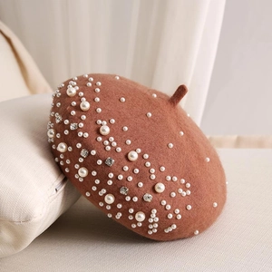 Close-up of brown wool beret featuring elegant pearl and rhinestone embellishments