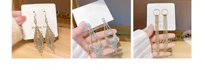 Dettaglio di tre eleganti orecchini a nappa con strass scintillanti nei colori oro e argento