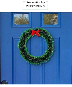 Close-up of a festive Christmas wreath with a red bow on a blue door background