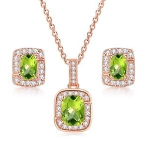Detailed close-up of rose gold jewelry set featuring rectangular green zircon stones