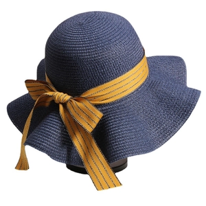 Navy blue straw sun hat with a large brim and striped yellow ribbon for beach vacation