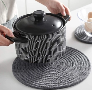 Macro shot of a grey cotton braided heat resistant placemat being used for a pot