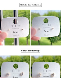 Macro shot of minimalist stainless steel stud earrings set with zircon stars and round studs