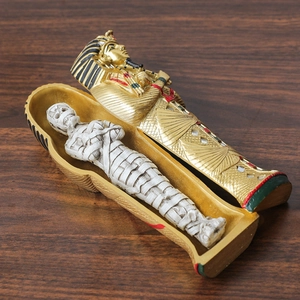 Ancient Egyptian Tutankhamun resin sarcophagus with white mummy figure on wood