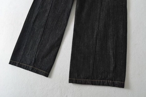Dettaglio dell'orlo dei jeans neri con cuciture a contrasto dorate di alta qualità