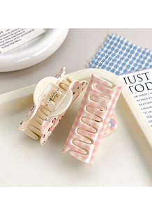 Detail of floral cherry and pink checkered patterns on acrylic hair claw clips