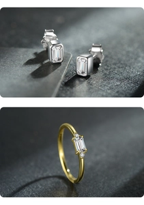 Detailed view of silver rectangular zircon earrings and a gold zircon ring on a black background