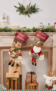 Close-up of reindeer and Santa fabric Christmas stockings hanging on a festive mantel