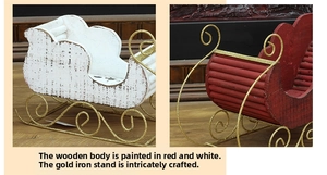 Detail of handcrafted wood and iron Christmas sleigh ornaments in red and white finishes