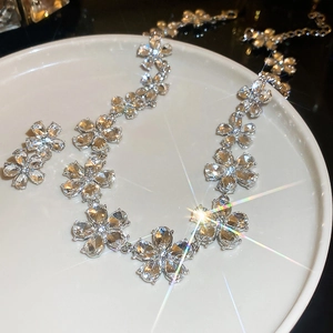 Elegant silver flower jewelry set with necklace and earrings featuring sparkling crystals