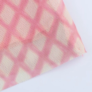 Détail du tissu en maille rose et beige avec texture raffinée à carreaux en losange