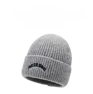 Macro detail of grey knit beanie featuring narazon embroidery and vertical rib texture